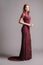 Posh burgundy evening dress. Luxury female gown. Young adult lady, studio shot. Bridesmaids red lace dress.