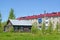 POSHEKHONJE, RUSSIA. The old wooden house with the announcement of sale against the background of the apartment brick building