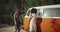 Posing beautiful young woman in front of her African friend female , behind the retro bus , smiling and dancing taking