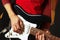 Posing hands of guitarist playing the electric guitar on black background