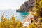 Positano cityscape on rocky landscape, people on the beach, boats are coming and going to the sea tours, scenic promenade on the