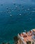 Positano, Italy - August 12, 2019: Tourists enjoy summer sunbath in hotel balcony with sea yachts view