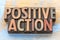 Positive action - word abstract in wood type