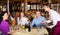 Positive adults sitting at table in restaurant during friendly meeting