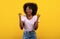 Positive african american lady gesturing YES, feeling excited and triumphant on yellow studio background