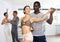 Positive African american man dancing playful Latin dance bachata with female partner during group class in choreography