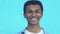 Positive African-American teen boy laughing at camera against blue background