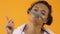 Positive african teenager holding pencil between nose and lips, mustache joke