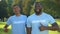 Positive afro-american males showing thumbs up, nature preservation volunteering