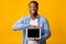 Positive Afro Man Showing Blank Tablet Screen, Yellow Background, Mockup