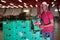 Positive Afro workman stacking boxes with harvested peaches on fruits sorting department