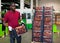 Positive Afro workman stacking boxes with harvested peaches on fruits sorting department