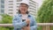 Positive age Asian female architecture in hardhat hold a tablet and standing in front of the city to inspect the building after