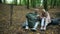 Positive aged couple enjoying their touristic lunch in the forest