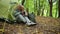 Positive aged couple using photo camera while in the forest