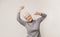 Positive aged lady dancing over light studio background