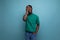 positive american young man with dreadlocks in casual green t-shirt on background with copy space