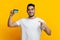 Positive arab guy recommending credit card, yellow background