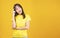 Positive Asian woman think choice creative on yellow background. Smile girl thinking about question, pensive expression something