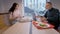 Positive beautiful Caucasian woman dining with busy senior businessman. Side view portrait of smiling young lady talking