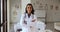 Positive beautiful young Hispanic doctor woman wearing white coat