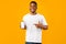 Positive Black Guy Showing Phone Empty Screen On Yellow Background