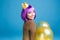Positive brightful emotions of joyful young woman with cut purple hair celebrating party with balloons on blue