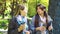 Positive business women walking in garden