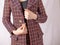 Positive businesswoman fastens button on tweed jacket