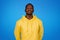 Positive calm young black guy in yellow sweatshirt with closed eyes enjoys free time, quiet, rest and relax