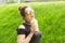 Positive cheerful young woman in stylish punk clothes and glasses holding a milkshake in her hands during a walk in the