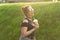 Positive cheerful young woman in stylish punk clothes and glasses holding a milkshake in her hands during a walk in the