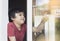 Positive child boy sitting at the window writing on glass and  with smiling face, School kid in self isolation relaxing at home