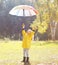 Positive child with colorful umbrella having fun