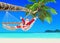 Positive Christmas Santa Claus relax in hammock at palm beach