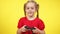 Positive confident baby girl playing video game using game console. Portrait of charming engrossed Caucasian kid gaming