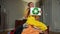 Positive confident teen girl showing recycling symbol sitting on heap of clothes smiling. Wide shot of happy Caucasian
