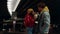 Positive couple eating snacks food at night. Man feeding woman under bridge.