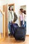 Positive couple with luggage in home going on holiday