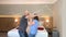 Positive couple, middle-aged man and woman in bathrobes dancing in hotel room, concept of vacation, travel, lifestyle