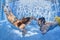 Positive couple swimming underwater in outdoor pool