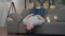 Positive creative Asian young man thinking lying upside down on couch with laptop. Wide shot portrait of inspired