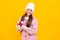 positive cute kid in winter hat with box. teen girl in mittens hold present