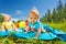 Positive cute toddlers sit on blanket in field