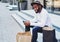 positive dark skinned man in stylish hat resting after shopping time