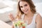 Positive delighted woman eating salad