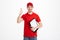 Positive deliveryman in red t-shirt and cap smiling and showing