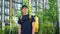 Positive deliveryman worker wears t-shirt and cap on background modern building