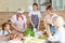 Positive diverse generation family women chopping ingredients for pizza, cooking