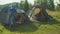 Positive diverse multiethnic backpackers enjoying leisure at campsite during mountain hiking